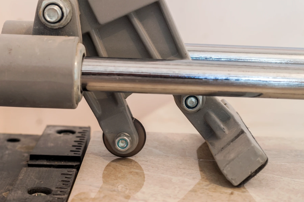 Fliesenschneider mit rollendem Schneidkopf auf Fliesenarbeitsfläche