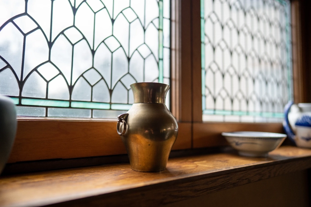 Metallvase auf elegant renoviertem Holzfensterbrett mit dekorativer Verglasung – Fensterbänke innen